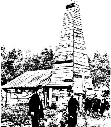 A person standing next to a wooden tower

Description automatically generated